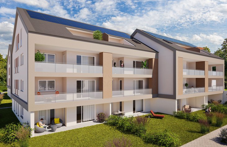 Moderne Wohnanlage mit drei Mehrfamilienhäusern, Flachdach und Solarpaneelen, umgeben von Bäumen und Wegen und Balkonen.