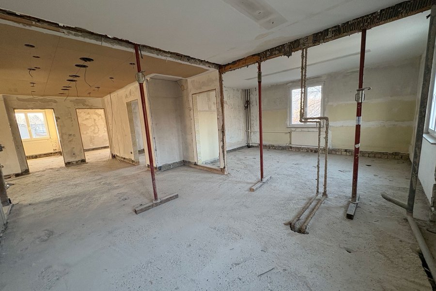 Innenraum im Rohbauzustand Großzüglicher Innenraum im Rohbauzustand mit freigelegten Decken, provisorischen Stützen und sichtbaren Leitungen während der Umbauarbeiten.