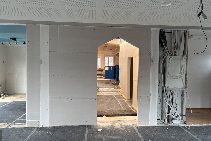 Trockenbauwände mit Durchgangsöffnung Neu errichtete Trockenbauwände mit Durchgangsöffnung, sichtbarer Elektroverkabelung und vorbereiteten Deckenflächen im Innenausbau.